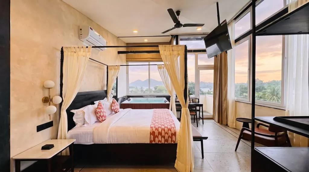 Luxury Lake View Suite with Jacuzzi: four-poster bed, private Jacuzzi and wide windows facing the Udaipur lakes and hills