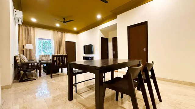 Superior 2 BHK Suite living lounge and dining table with doors to the bedrooms