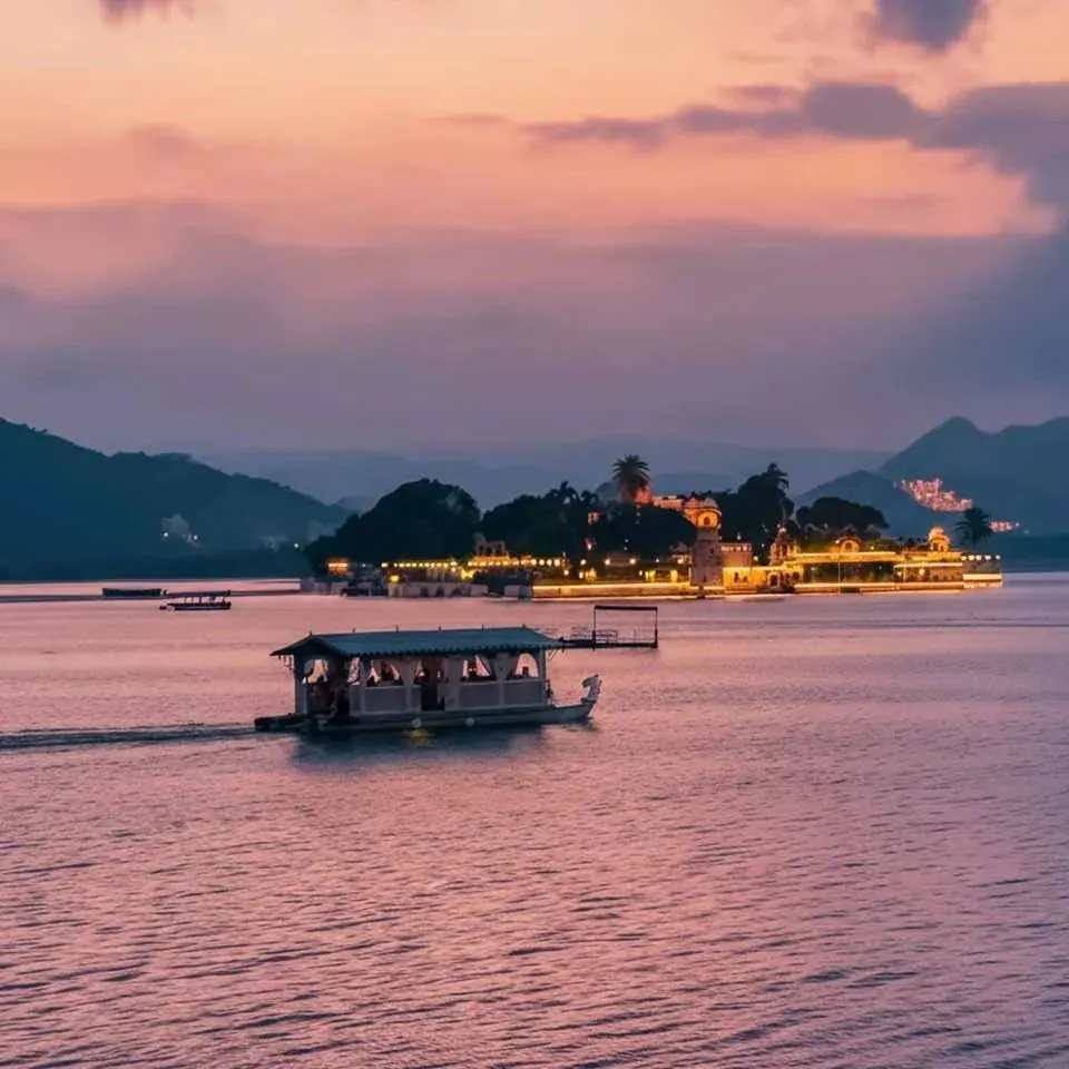 A boat on Lake Pichola, Udaipur, with the lit palace behind
